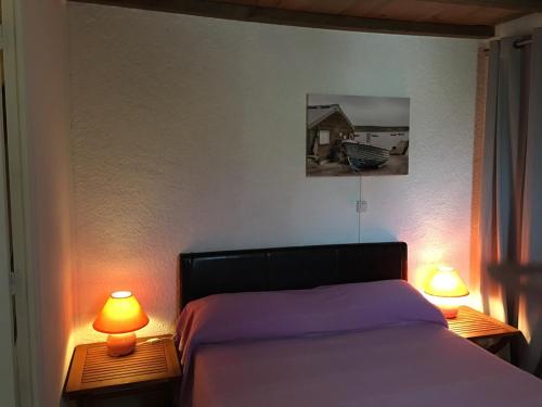 - une chambre avec un lit et deux lampes sur les tables dans l'établissement Villa Maxime, à Porto-Vecchio