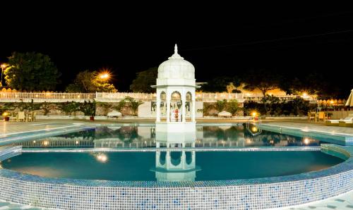 a building with a pool at night at Pratap Mahal Pushkar IHCL SeleQtion in Pushkar