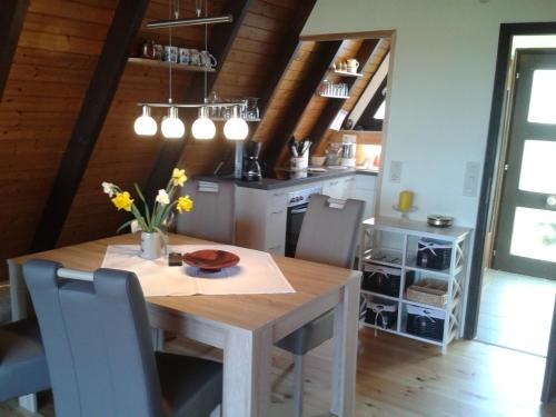 a dining room with a wooden table and chairs at Eifeler Finnhaus mit Sauna, Mühlenberg 13 in Dockweiler
