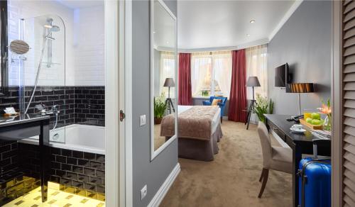 a bathroom with a tub and a bedroom at Easy Room in Nizhny Novgorod