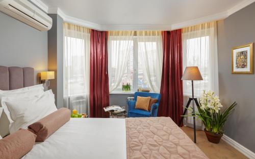 a bedroom with a large bed with red curtains at Easy Room in Nizhny Novgorod