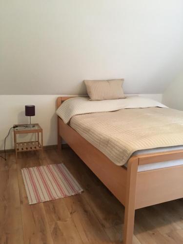 a bedroom with a bed and a small table at Lesny Apartament in Ostrzyce