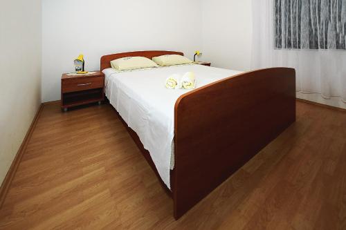 Un dormitorio con una cama grande con dos zapatos. en Apartments Bijuk, en Sukošan