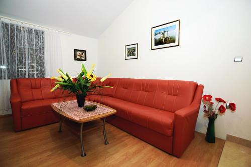 sala de estar con sofá rojo y mesa en Apartments Bijuk, en Sukošan