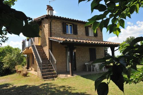 a brick house with a staircase in front of it at Agriturismo Podernuovo in Acquapendente