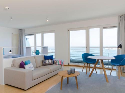 sala de estar con sofá, mesa y sillas en atoll apartments, en Helgoland