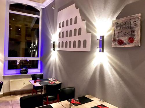 a restaurant with tables and lights on a wall at Hotel-Restaurant Windsor in Mondorf-les-Bains