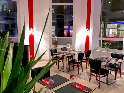 jadalnia ze stołami, krzesłami i czerwonymi paskami w obiekcie Hotel-Restaurant Windsor w mieście Mondorf-les-Bains