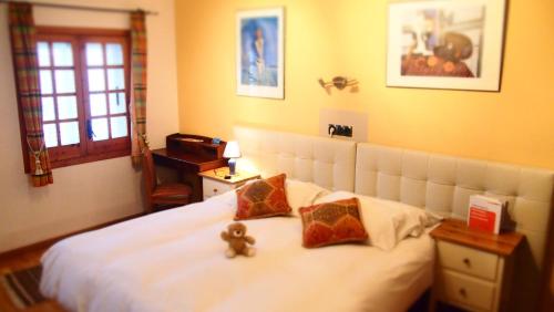 a bedroom with a bed with two teddy bears on it at Privat Hotel Liberty Sitges in Sitges