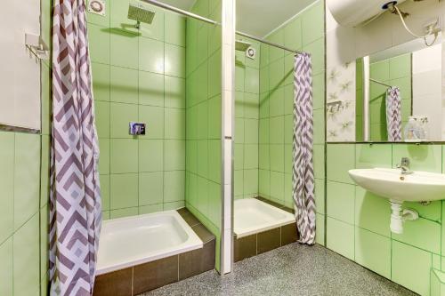 uma casa de banho verde com um lavatório e um chuveiro em Tetris Sopot em Sopot