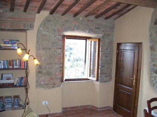 Cette chambre dispose d'une fenêtre et d'une porte en bois. dans l'établissement Casa Bella Vista, à Pereta