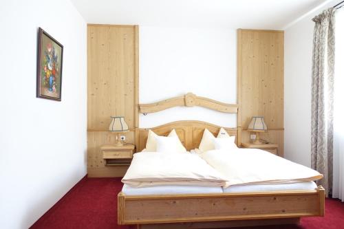 a bedroom with a large bed with white sheets at Hotel Gasthof Schönblick in Neumarkt in der Oberpfalz