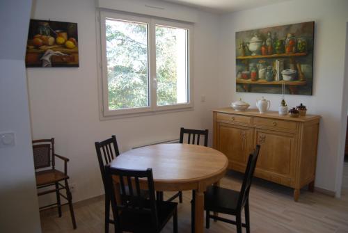 a dining room with a table and chairs and a window at Ramier in Giverny