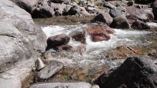 a stream of water with rocks on a mountain at casa del cirillo in Ornica
