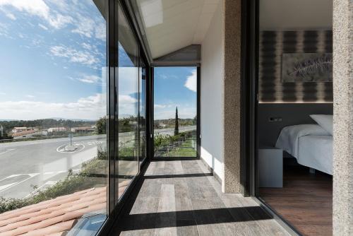 a bedroom with a view of a road and a bed at Pension Residencial Victoria in Santa Cruz de Ribadulla