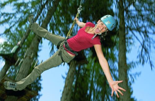 a woman is hanging on a rope swing at Sölle Homes Nassfeld in Sonnenalpe Nassfeld