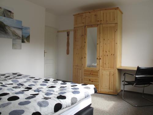 Schlafzimmer mit einem Bett, einem Schreibtisch und einem Schrank in der Unterkunft Ferienwohnung Ostseenähe in Hirschburg