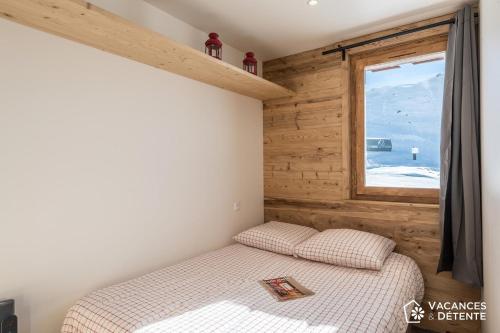 a small bedroom with a bed and a window at Nazca C8 in Val Thorens