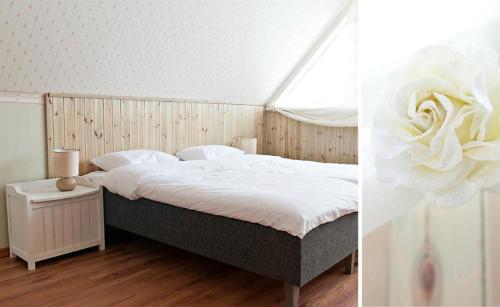 Un dormitorio con una cama con una flor. en Männiaru Puhkemajad BO KA Pubi, en Oru