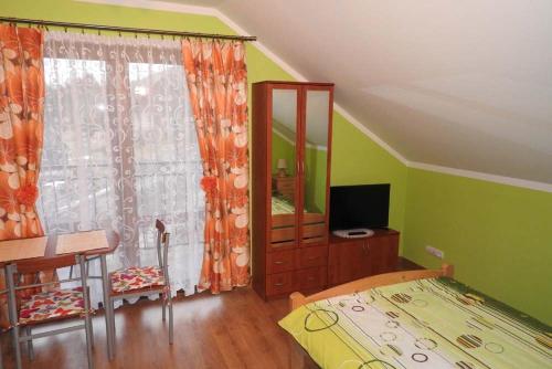 a bedroom with a bed and a desk and a mirror at U Piotrka in Sopotnia Wielka