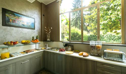 a kitchen with a counter with a microwave and windows at Hotel San Francisco in Milan