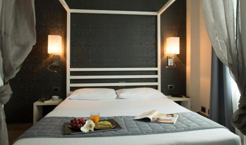 a bed with a tray of food on it at Hotel San Francisco in Milan