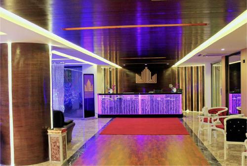 a lobby with a bar with purple lighting and a red carpet at Hotel Noorjahan Grand in Sylhet