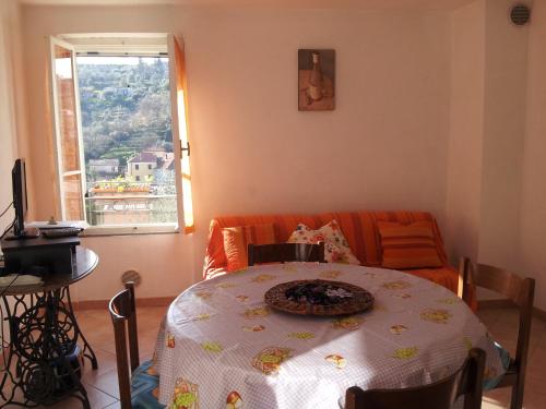 a living room with a table and a couch and a window at Alloggio Lavanda in Diano San Pietro