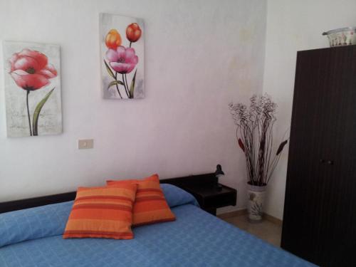Diano San PietroにあるAlloggio Lavandaのベッドルーム1室(壁に絵画2点が飾られたベッド1台付)