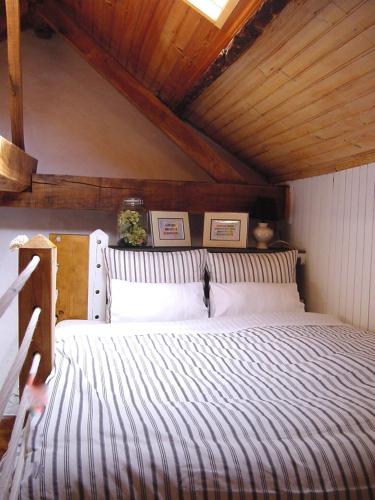 a bedroom with a large bed with a wooden ceiling at SaberAmar Little Country in Arouca