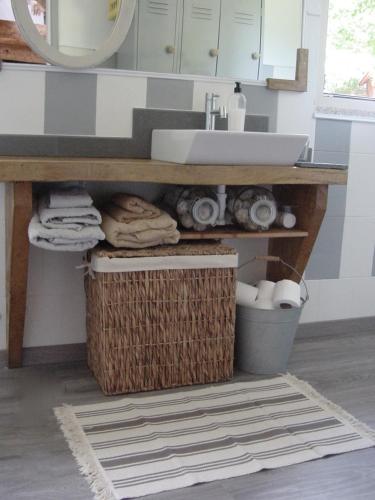 a bathroom with a sink and a basket under a counter at SaberAmar Little Country in Arouca