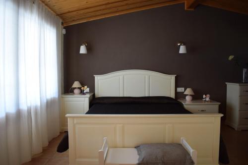 a bedroom with a large bed with a white headboard at La Parcela in Riumar