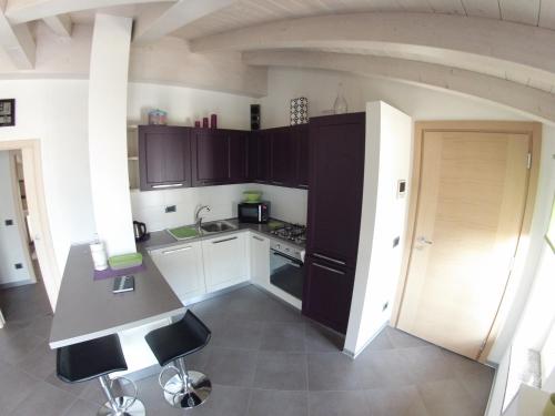 una cucina con mobili neri e un piano di lavoro di La Bella Corte ad Arco