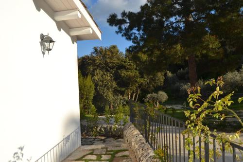 a white house with a fence and a tree at Locanda Angelica in Giarratana