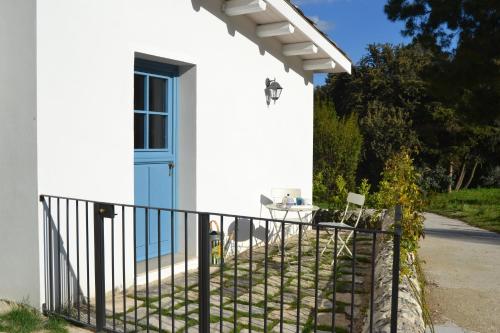 a white house with a blue door and a fence at Locanda Angelica in Giarratana