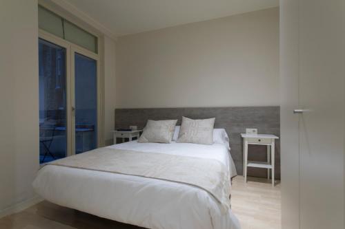 ジローナにあるBravissimo Cort Reial-2Aのベッドルーム1室(白い大型ベッド1台、テーブル2台付)