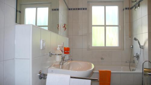 a white bathroom with a sink and a bath tub at Apartment Rudi in Garmisch-Partenkirchen