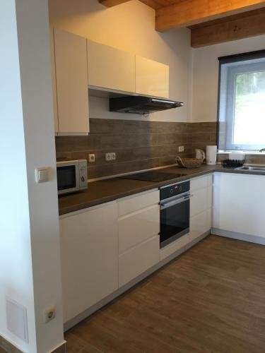 a kitchen with white cabinets and a stove top oven at Lesny Apartament in Ostrzyce