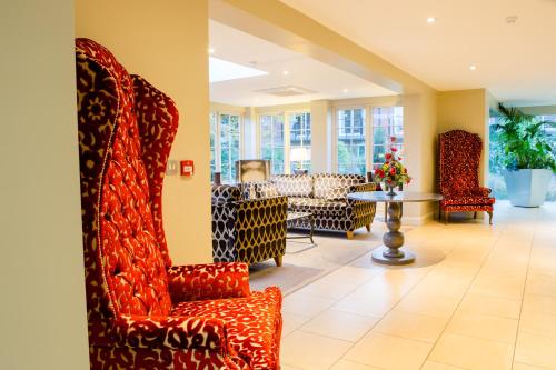a lobby with several chairs and a table at Park Farm Hotel in Norwich