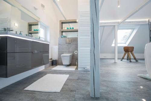 ギュータースローにあるDesign-Studiowohnung Haegestrasseの白いバスルーム(洗面台、トイレ付)