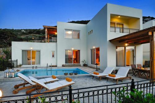 a villa with a swimming pool in front of a house at Istron Collection Villas in Istro