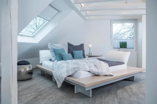 a white bedroom with a large bed and a window at Design-Studiowohnung Haegestrasse in Gütersloh