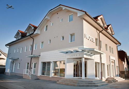 a large white building with a store front at Hotel Bajt Maribor in Maribor