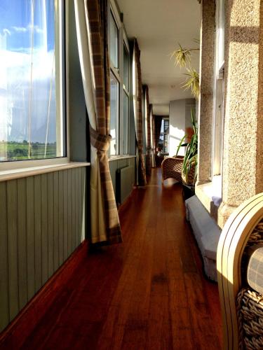 a hallway with windows and a hard wood floor at Membly Hall Hotel in Falmouth