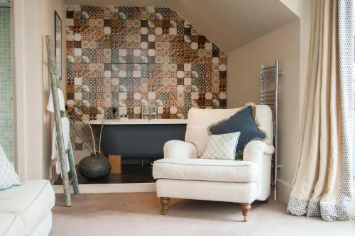 a living room with a chair and a bath tub at The Grosvenor Arms in Shaftesbury
