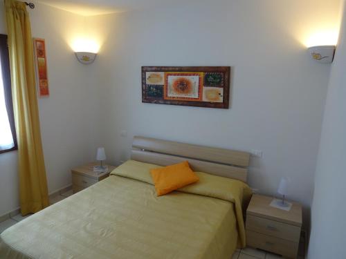サン・パスクアーレにあるLa Pavoncellaのベッドルーム1室(オレンジ色の枕が付いたベッド1台付)