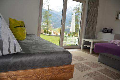 Schlafzimmer mit einem Bett und einer Glasschiebetür in der Unterkunft Ferienwohnungen Unterluimes in Telfes im Stubai