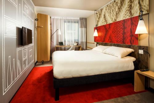a hotel room with a large bed and a television at ibis Cambridge Central Station in Cambridge