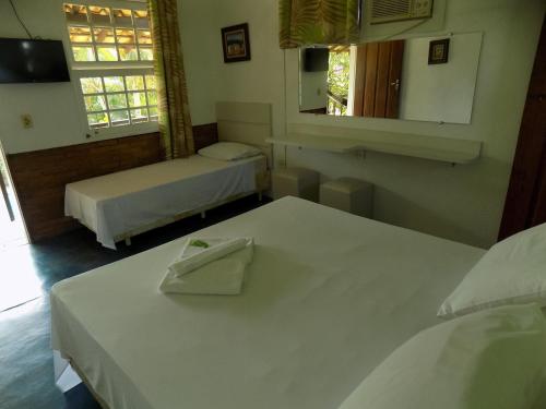 a hotel room with two beds and a mirror at Atobá Villas in Paraty