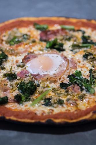 a pizza with broccoli and an egg on it at The Grosvenor Arms in Shaftesbury